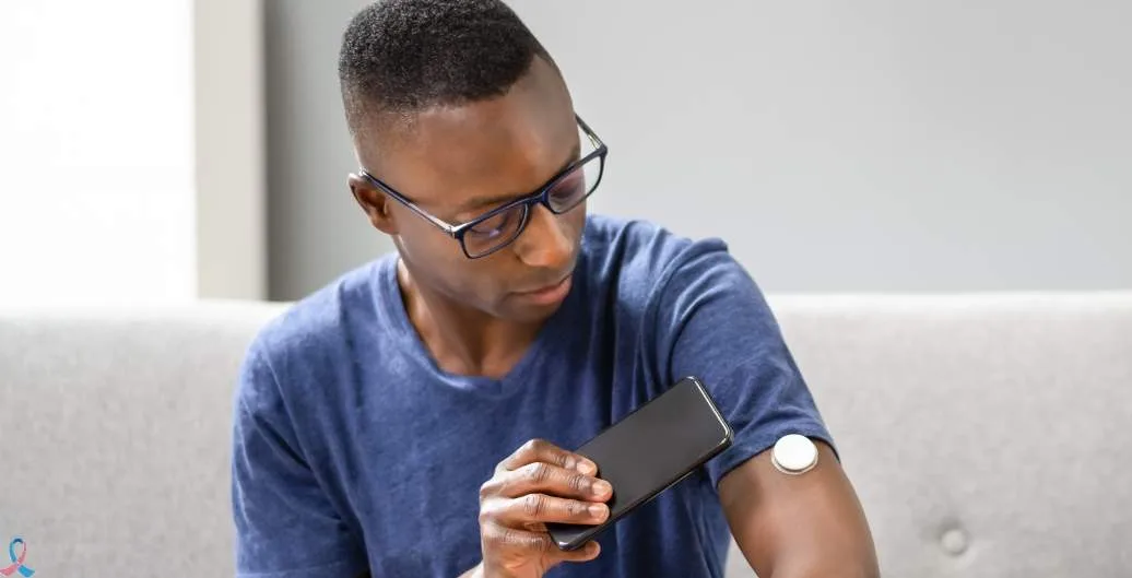 A man checking his glucose sensor with his phone.