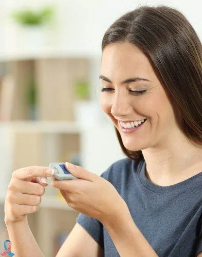 A woman smiling at her blood glucose meter.