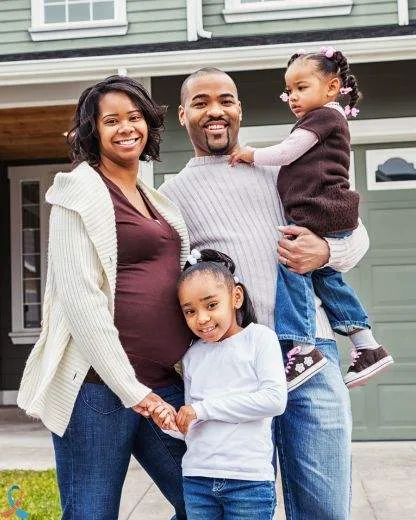 A family standing together outside their home.