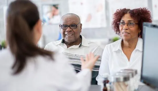 A diabetes care specialist talking with an older couple.