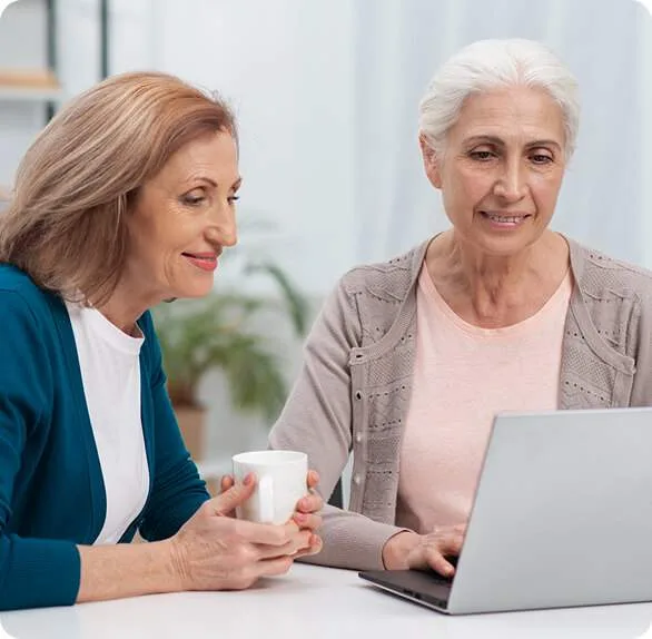 Two women looking at a laptop together.