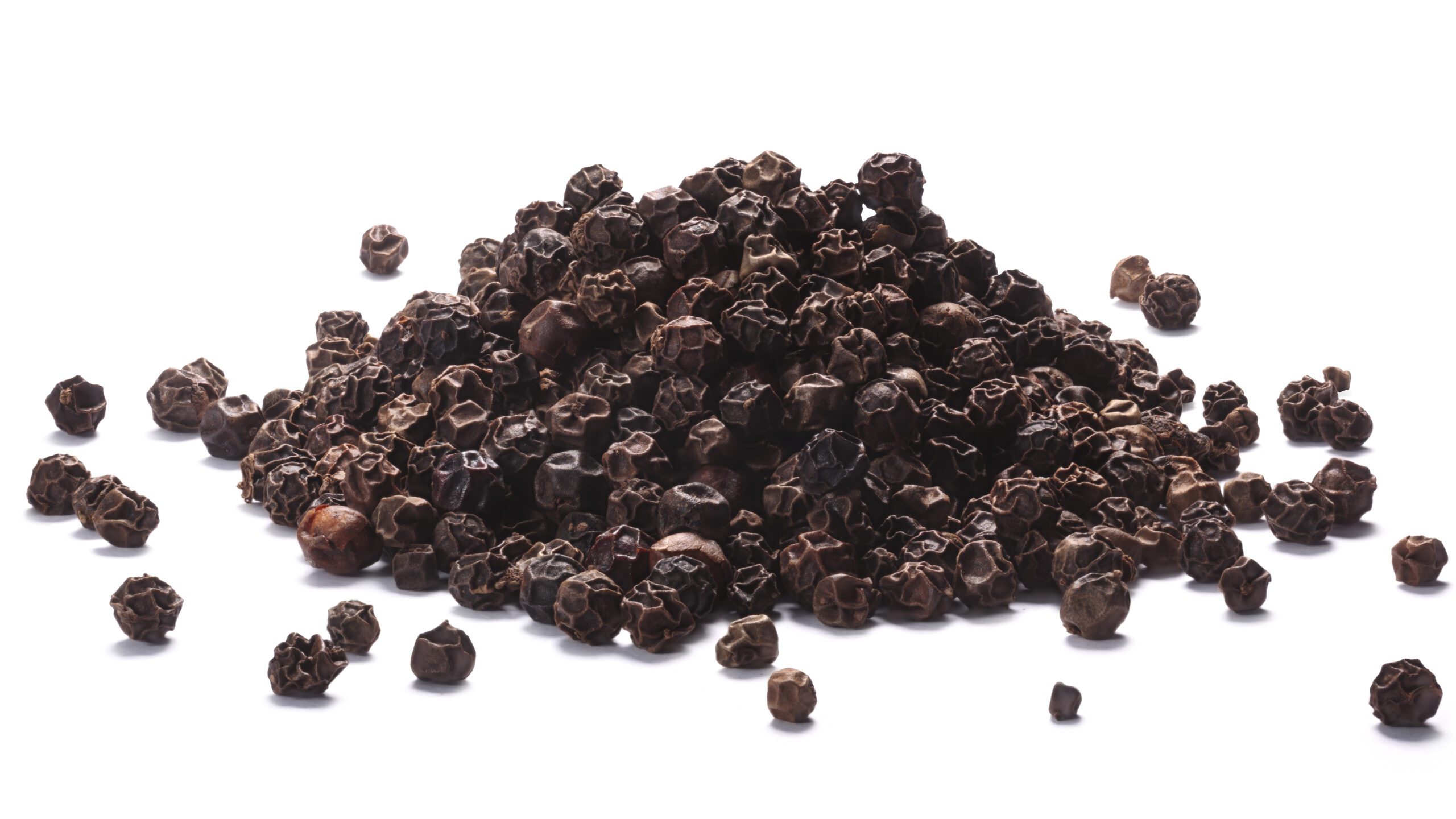 Pile of black peppercorns (dried seeds of Piper nigrum). Clipping paths, shadows separated